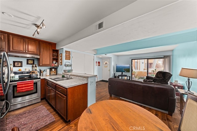 kitchen featuring stainless steel range with electric stovetop, a sink, under cabinet range hood, a peninsula, and open floor plan