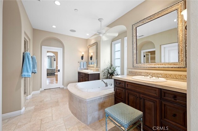 28 Surfspray Blf, Newport Coast, CA 92657 - full bath with two vanities, a jetted tub, ceiling fan, recessed lighting, and stone tile floors