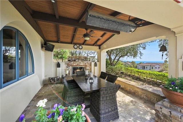 28 Surfspray Blf, Newport Coast, CA 92657 - view of patio / terrace with an outdoor stone fireplace, a ceiling fan, and outdoor dining space