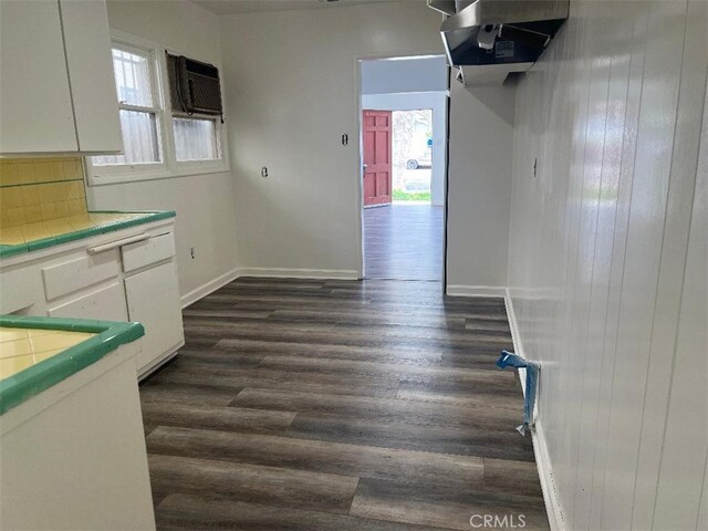 2223 W Olympic Blvd, Montebello, CA 90640 - interior space featuring baseboards, a healthy amount of sunlight, a wall mounted AC, and dark wood-style flooring