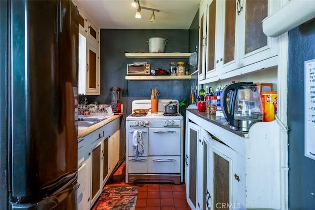 3124 Goodview Trl, Los Angeles, CA 90068 - kitchen featuring freestanding refrigerator, glass insert cabinets, dark tile patterned flooring, white range with gas stovetop, and a sink