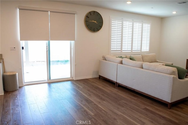 living room with baseboards, wood finished floors, and visible vents