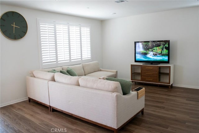 living room featuring dark wood-type flooring and baseboards