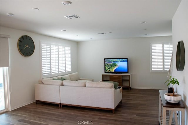 living area featuring plenty of natural light, baseboards, wood finished floors, and visible vents