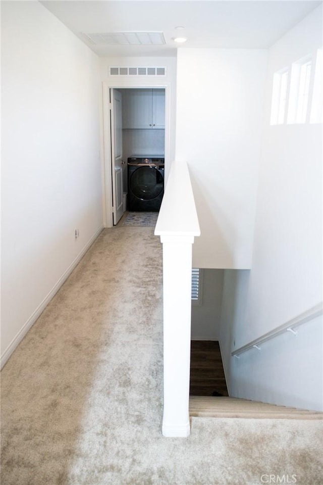stairway featuring visible vents, carpet flooring, washer / dryer, and baseboards