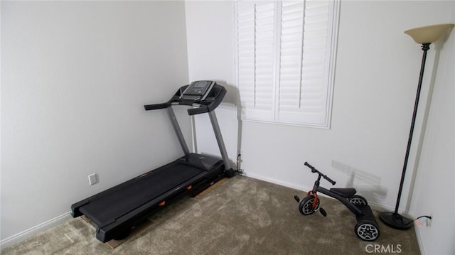 exercise room with baseboards and carpet flooring