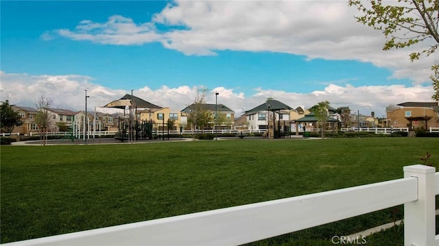 surrounding community with playground community, a yard, a residential view, and fence
