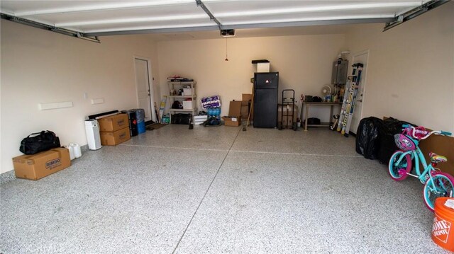 garage featuring freestanding refrigerator and a garage door opener