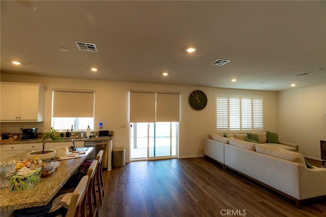 living area featuring recessed lighting, visible vents, and dark wood finished floors