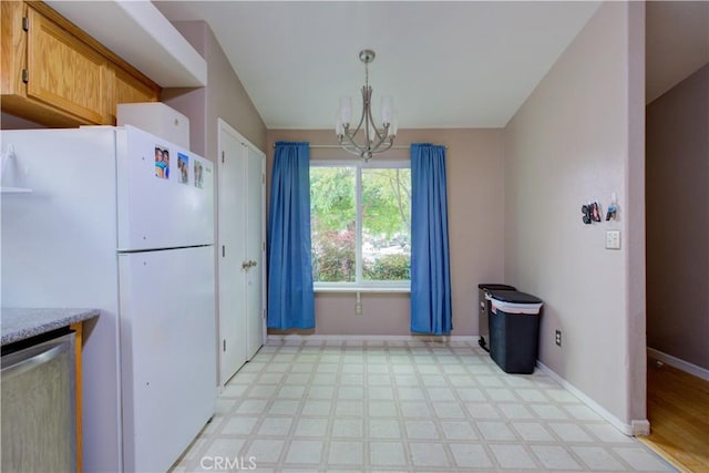 kitchen with freestanding refrigerator, dishwasher, an inviting chandelier, and light floors