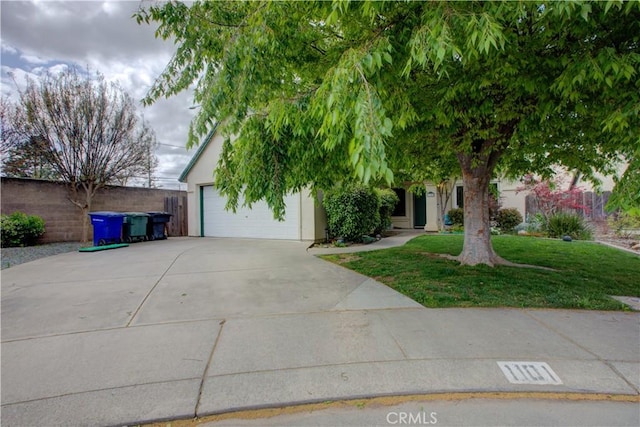 view of property hidden behind natural elements featuring stucco siding, fence, and a front lawn