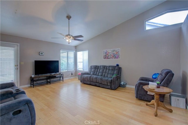 living area featuring baseboards, vaulted ceiling, wood finished floors, and a ceiling fan