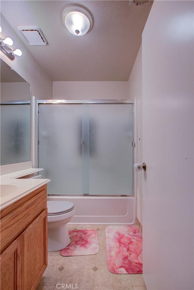 full bathroom featuring a textured ceiling, visible vents, combined bath / shower with glass door, toilet, and vanity