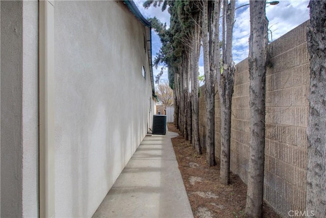 view of property exterior featuring central AC unit and fence