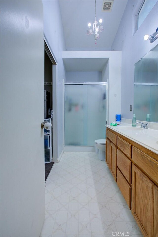 bathroom featuring a stall shower, toilet, vanity, a chandelier, and visible vents