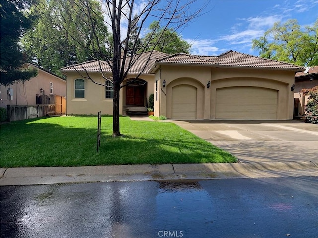 view of front of house with driveway, fence, a tiled roof, stucco siding, and a garage