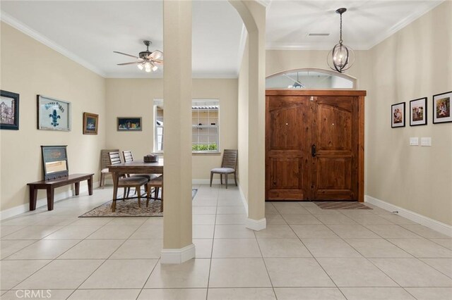 foyer entrance with baseboards, ornamental molding, ceiling fan, and light tile patterned flooring