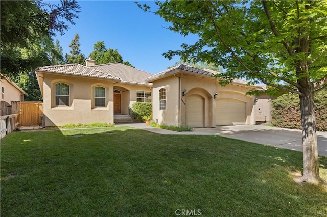 mediterranean / spanish-style house featuring a chimney, stucco siding, a tiled roof, fence, and a front lawn