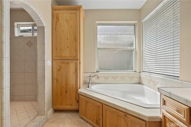 full bathroom with a bath and tile patterned flooring
