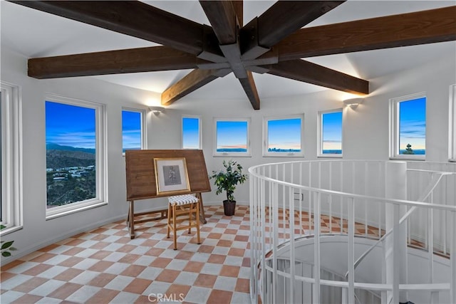 bedroom featuring baseboards, beamed ceiling, and multiple windows