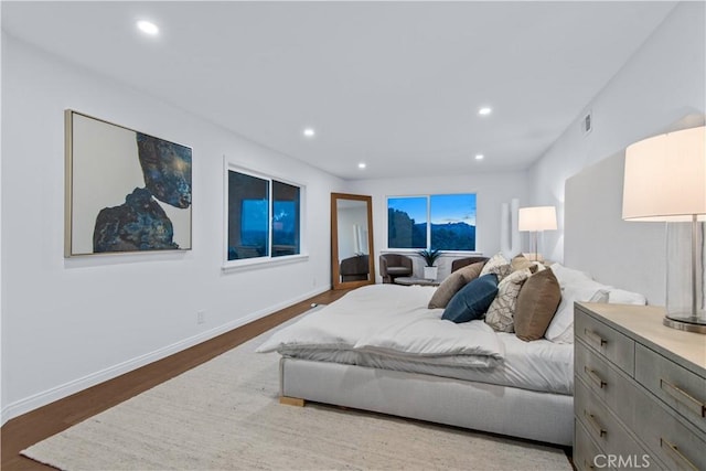 bedroom with baseboards, visible vents, wood finished floors, and recessed lighting