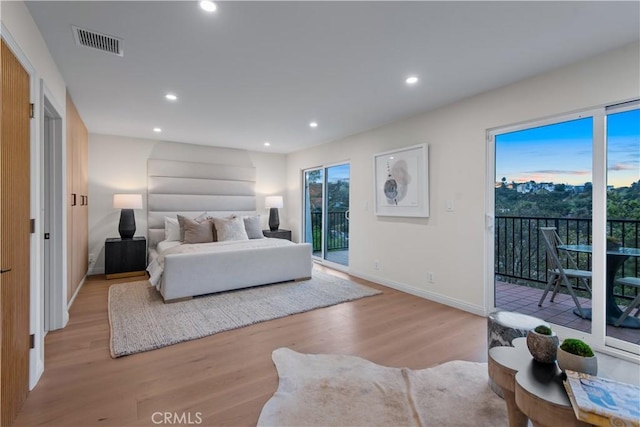 bedroom with light wood finished floors, visible vents, recessed lighting, and access to outside