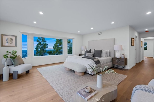 bedroom featuring baseboards, wood finished floors, and recessed lighting