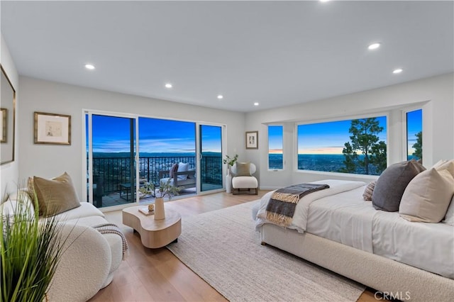 bedroom with wood finished floors, recessed lighting, and access to outside