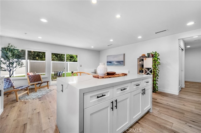 32772 Shipside Dr, Dana Point, CA 92629 - kitchen with light wood-style floors, white cabinetry, recessed lighting, a center island, and baseboards