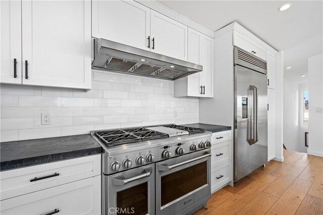 33781 Copper Lantern St, Dana Point, CA 92629 - kitchen featuring under cabinet range hood, white cabinetry, backsplash, high end appliances, and dark countertops