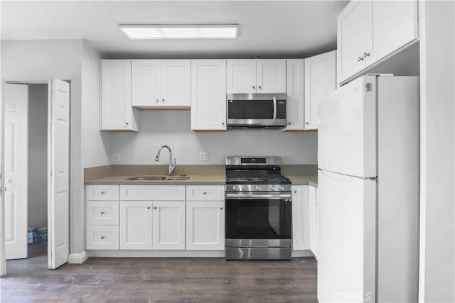 kitchen featuring white cabinetry, a sink, stainless steel appliances, light countertops, and dark wood-type flooring