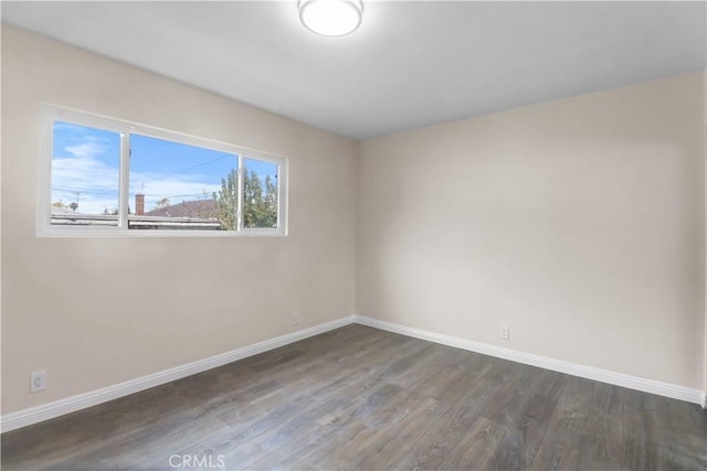 spare room with wood finished floors and baseboards
