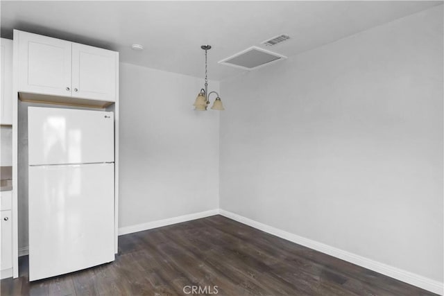 unfurnished dining area featuring visible vents, dark wood-style floors, and baseboards