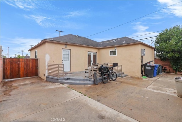 back of house with fence, french doors, stucco siding, and a patio area