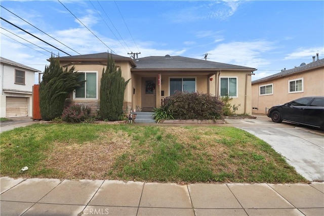 view of front of property with stucco siding and a front lawn