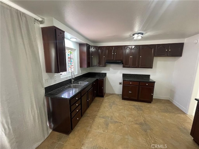 14802 Newport Unit 2B, Tustin, CA 92780 - kitchen featuring dark brown cabinets, under cabinet range hood, and dark stone countertops