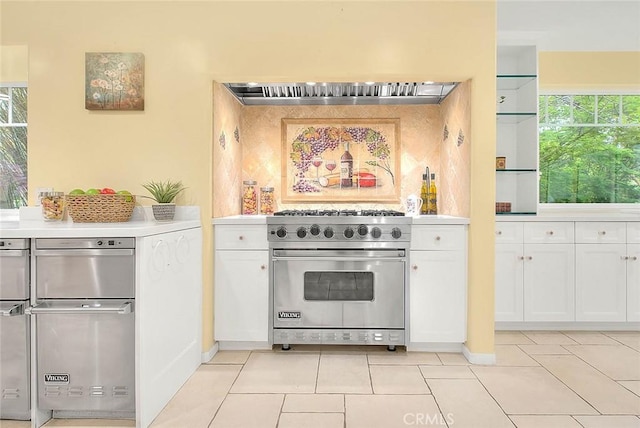 kitchen featuring plenty of natural light, premium stove, white cabinets, and light countertops