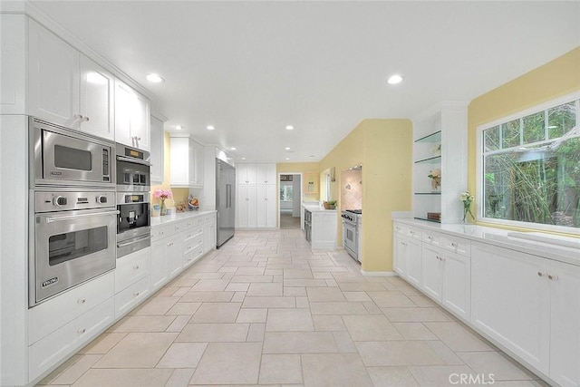 kitchen with built in appliances, light countertops, recessed lighting, and white cabinetry
