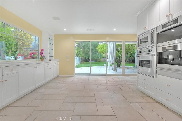 kitchen with recessed lighting, stainless steel appliances, light countertops, visible vents, and white cabinetry
