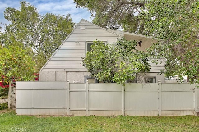 view of home's exterior featuring fence and a yard
