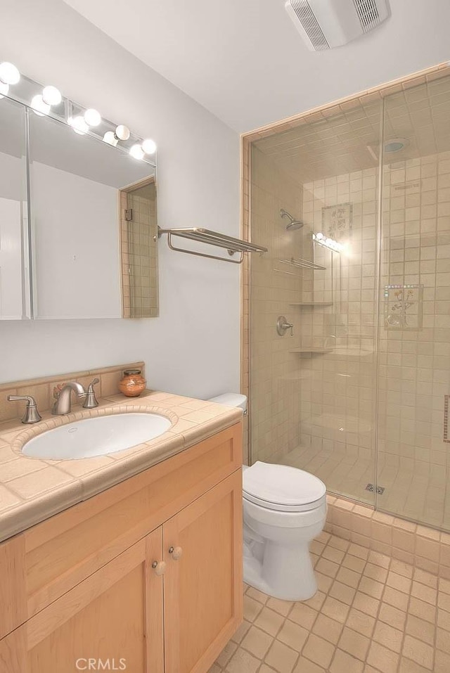 full bath with a shower stall, tile patterned floors, vanity, toilet, and visible vents