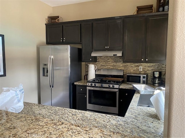 16001 Chase Rd Unit 59, Fontana, CA 92336 - kitchen featuring stainless steel appliances, tasteful backsplash, under cabinet range hood, and light stone counters