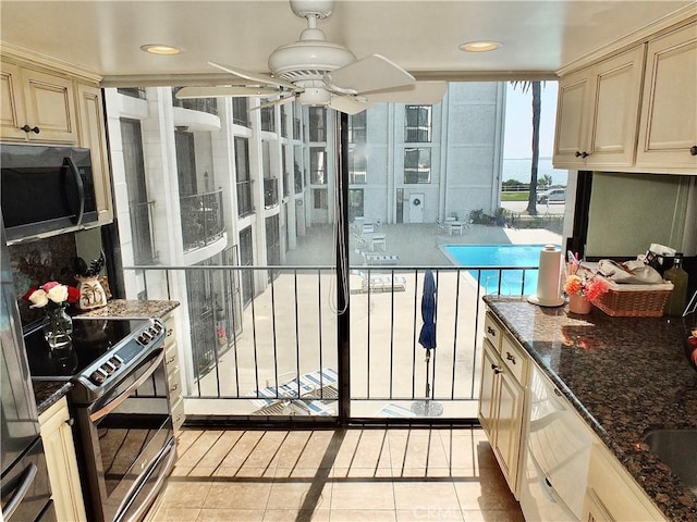 2601 E Ocean Blvd Unit 205, Long Beach, CA 90803 - kitchen featuring black electric range, light tile patterned flooring, cream cabinets, dark stone counters, and recessed lighting
