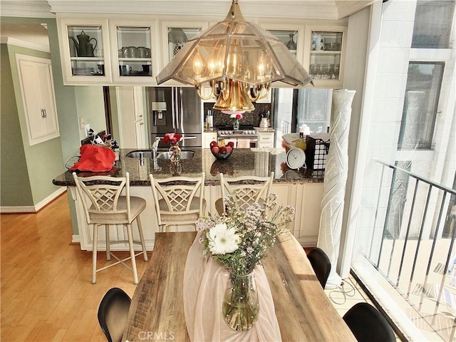 2601 E Ocean Blvd Unit 205, Long Beach, CA 90803 - kitchen featuring stainless steel appliances, a sink, light wood-style flooring, a chandelier, and ornamental molding