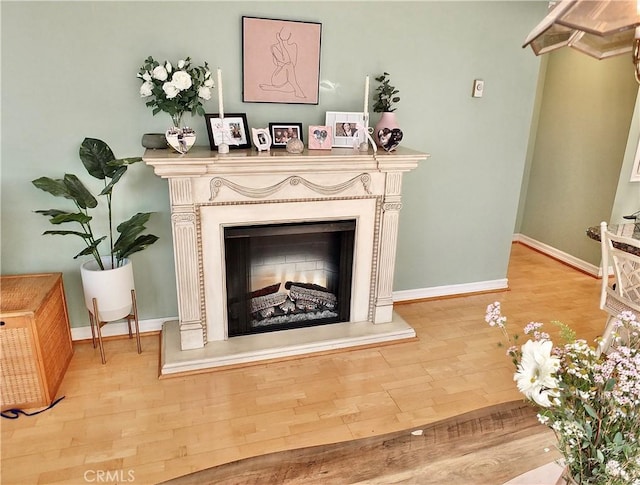 2601 E Ocean Blvd Unit 205, Long Beach, CA 90803 - detailed view of wood finished floors, a fireplace with raised hearth, and baseboards