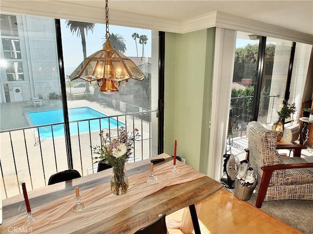 2601 E Ocean Blvd Unit 205, Long Beach, CA 90803 - dining area with a chandelier, wood finished floors, and crown molding