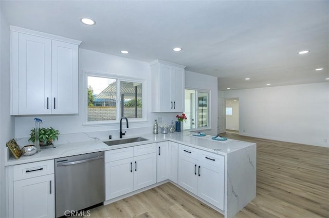 kitchen with light wood-type flooring, dishwasher, a sink, light stone counters, and recessed lighting