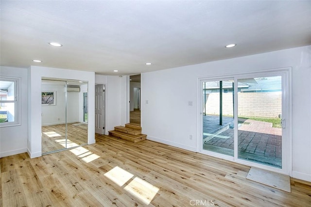 3518 Faust Ave, Long Beach, CA 90808 - empty room with plenty of natural light, light wood finished floors, recessed lighting, an AC wall unit, and stairs