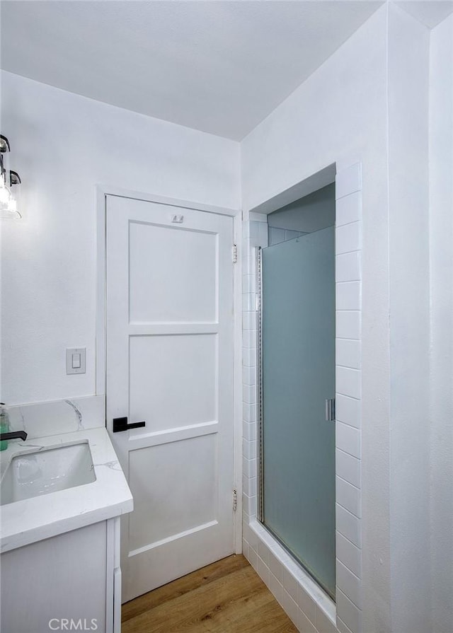 full bath featuring vanity, a stall shower, and wood finished floors