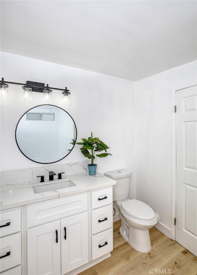 bathroom with vanity, toilet, and wood finished floors